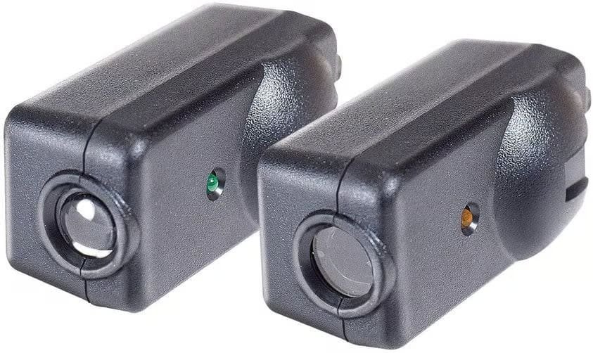 Pair of garage door safety sensors, one with a solid green light and one with a solid amber light