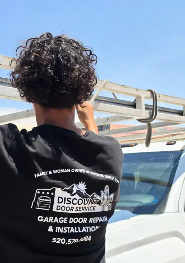 Discount Door Service technician in a branded shirt beside the service van at a garage door job in Gladden Farms, Marana