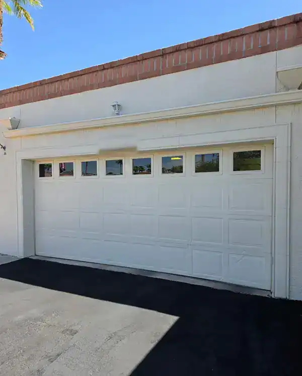 New white raised panel garage door with a row of windows on a townhome at Sonoran Palms Townhomes in Tucson, Arizona