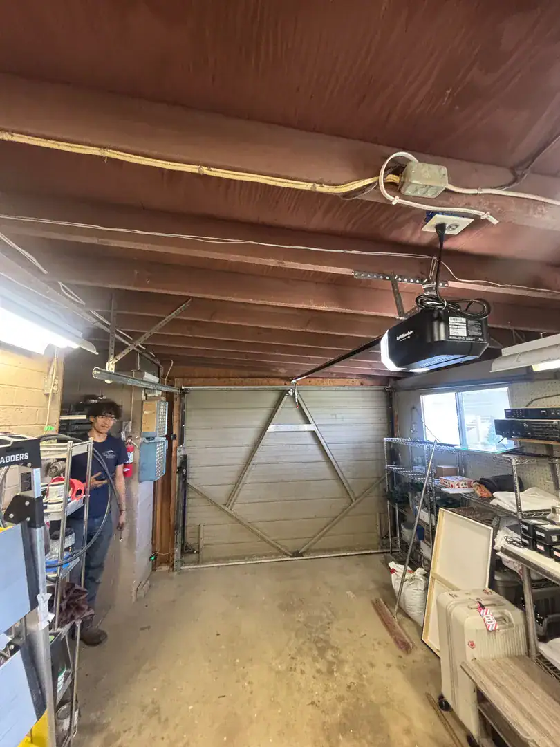 Technician working in a garage workshop with a wood beam ceiling