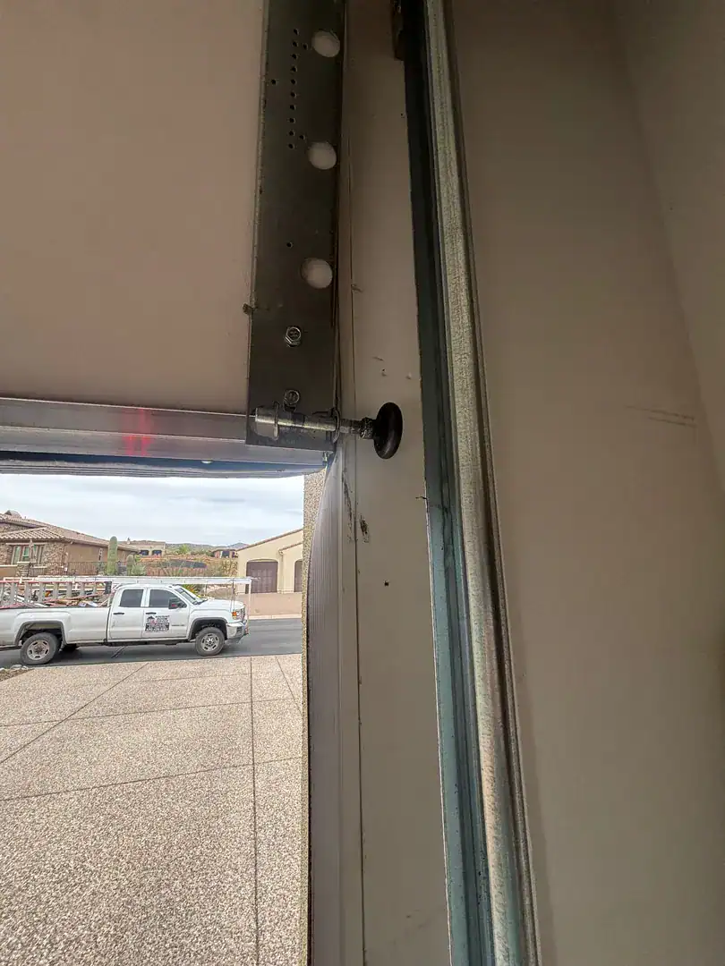 Service truck parked on the street, seen past a garage door track