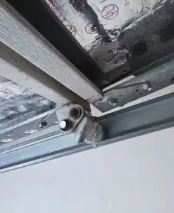 Garage door roller and hinge bracket in the track, with foam insulation behind the panel, garage door roller replacement in Tucson