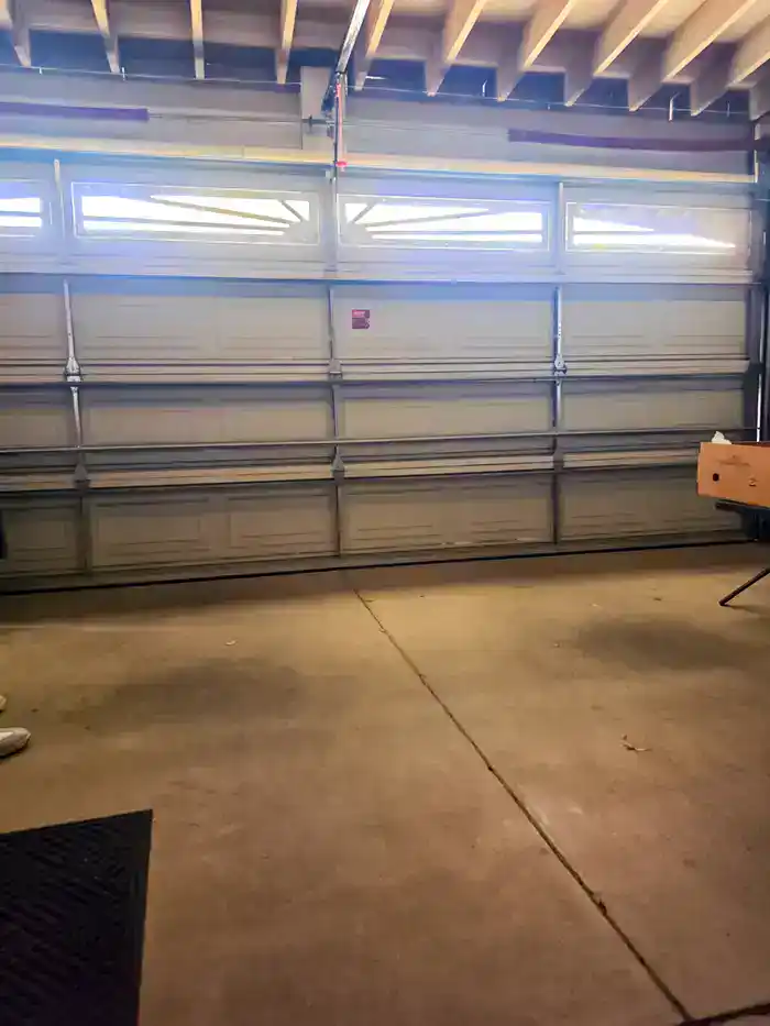 Inside view of a closed garage door showing its tracks and window panels