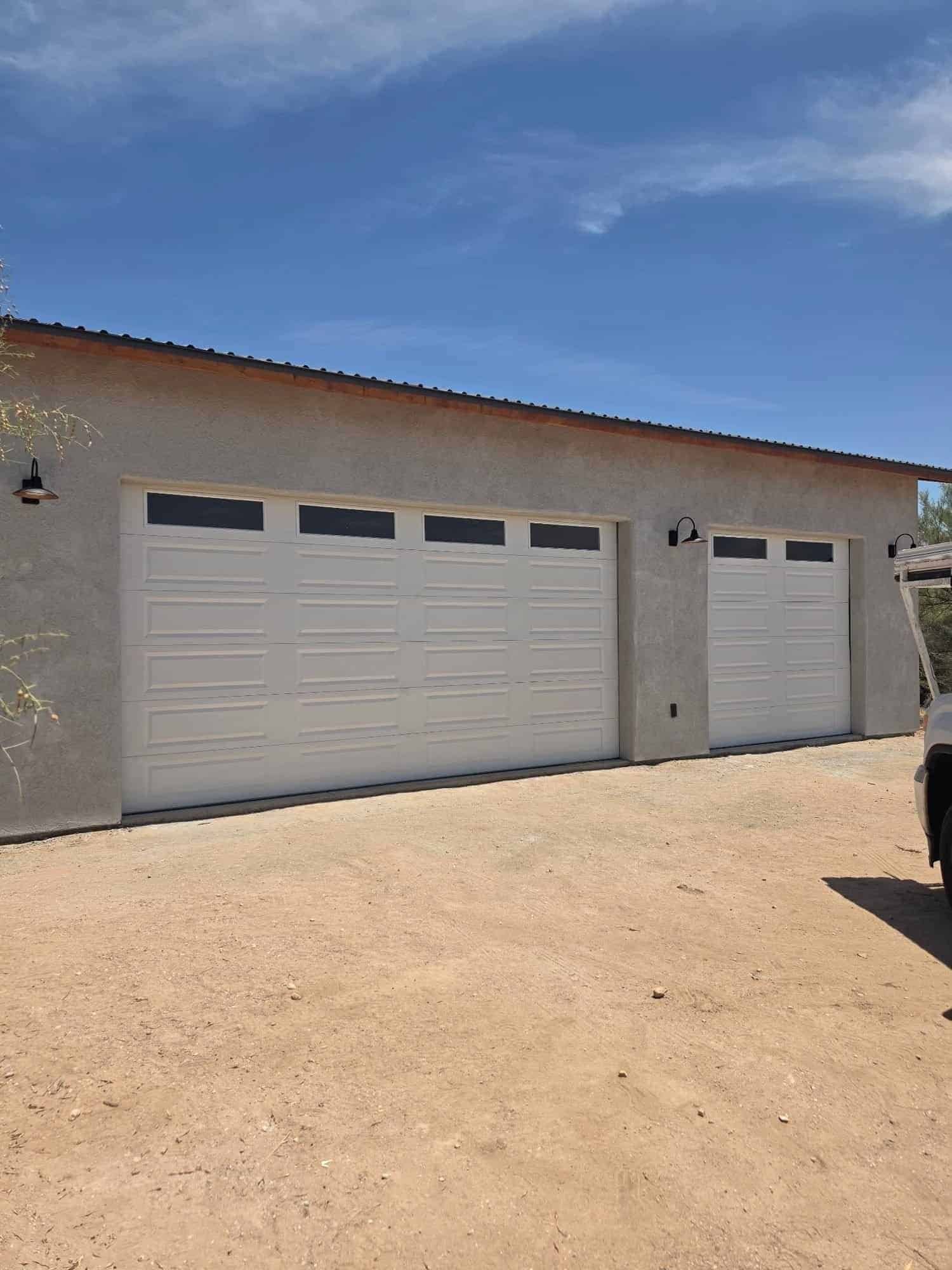 Light gray insulated steel garage doors with window sections on a Tucson home