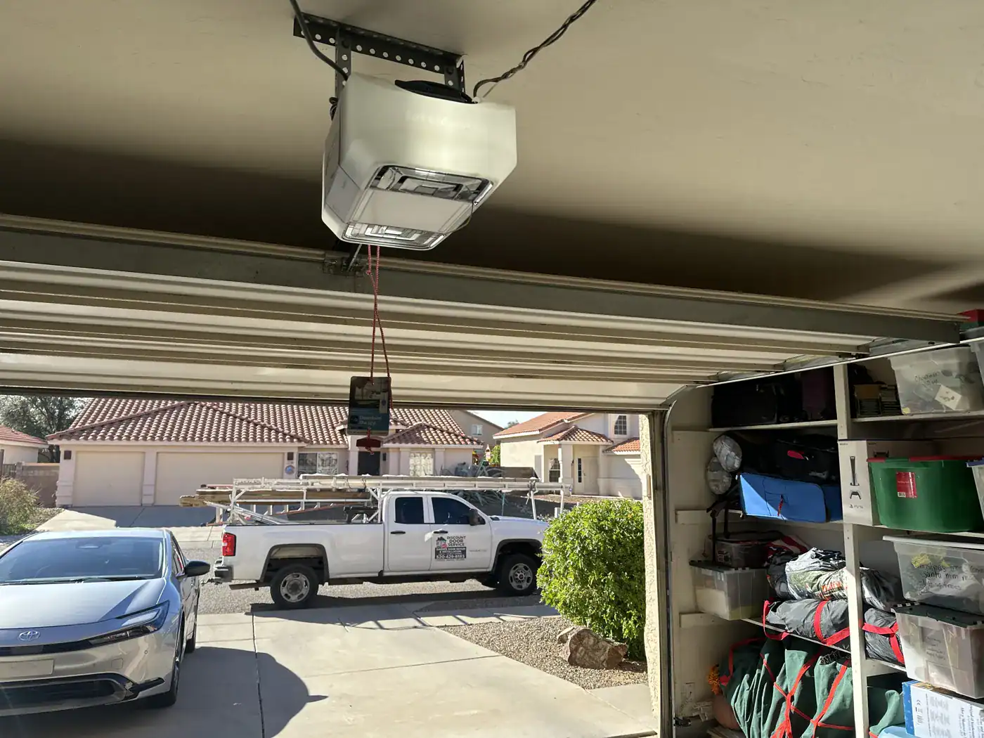 Opener above an open garage door with the service truck outside